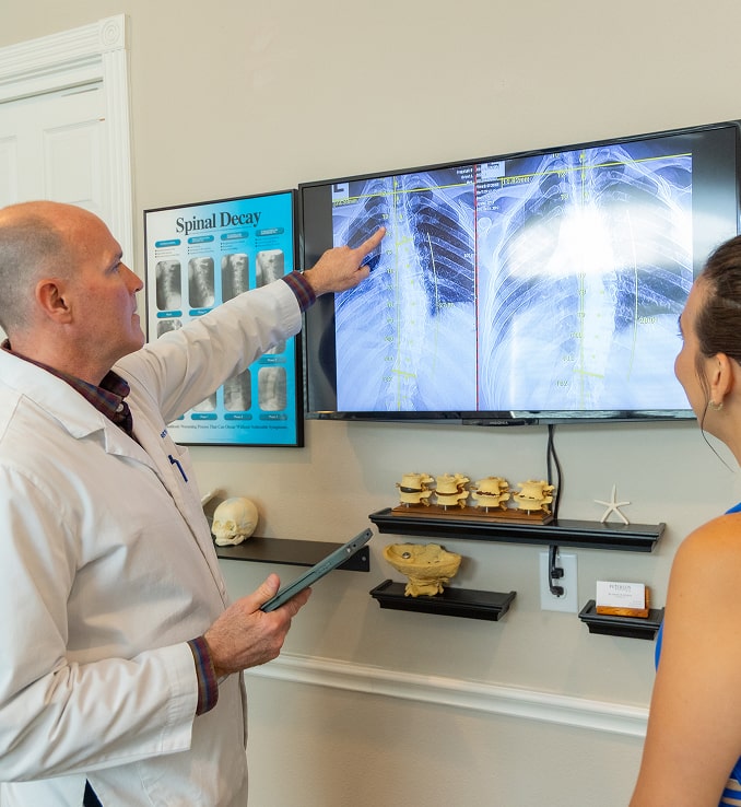 Doctor pointing out a patients spine to a patient