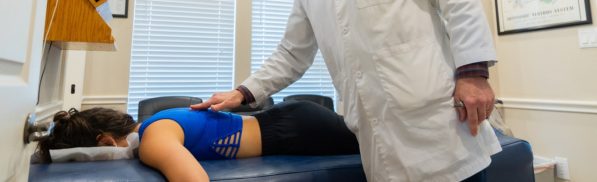 Doctor feeling a patients spine during an examination